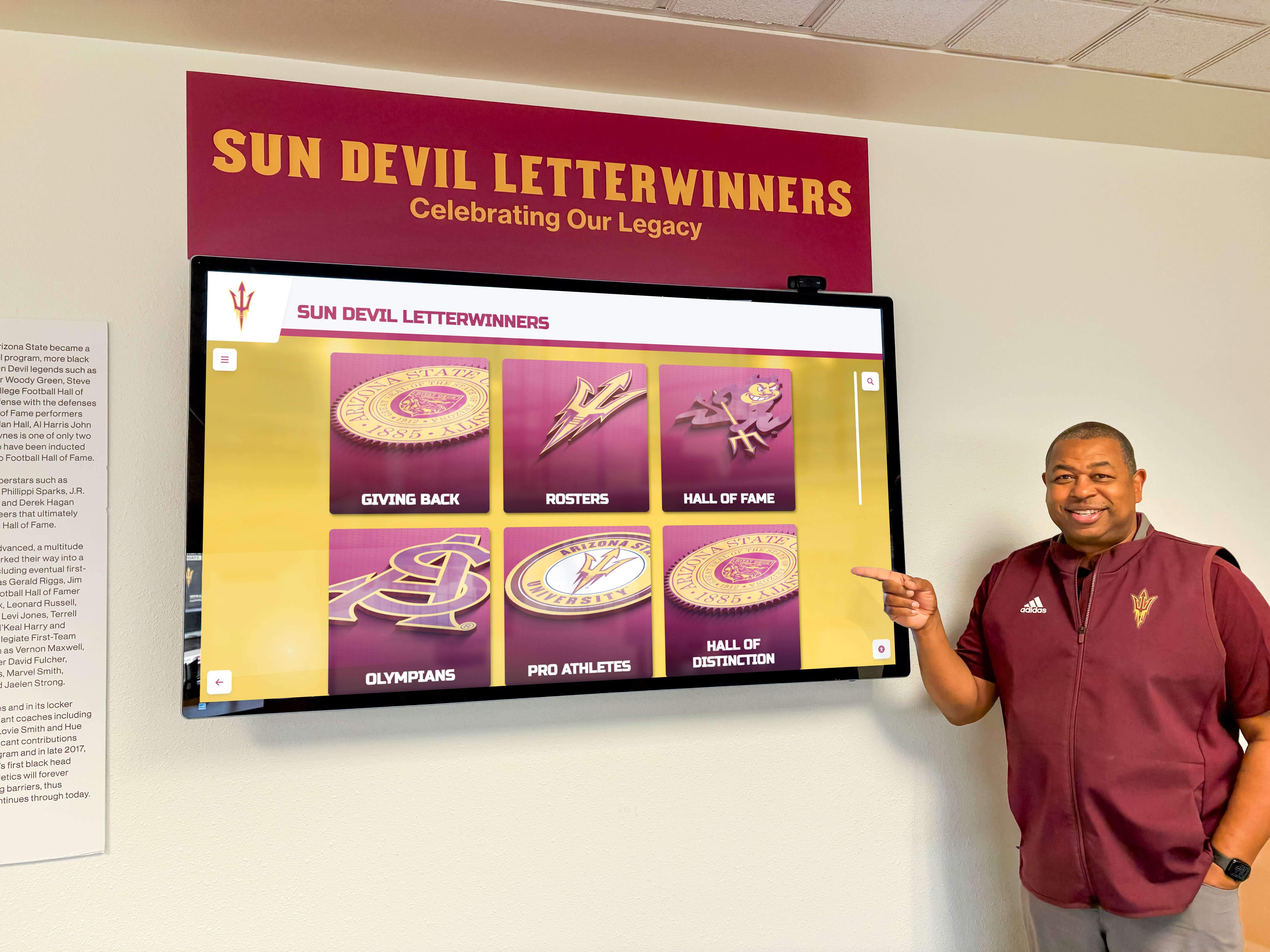 Interactive display showing athletic and academic letterwinners recognition at university Man pointing at Sun Devil letterwinners display showing achievement recognition
