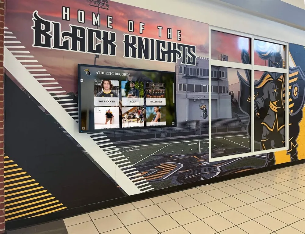 School hallway featuring Black Knights mascot mural with athletic records display