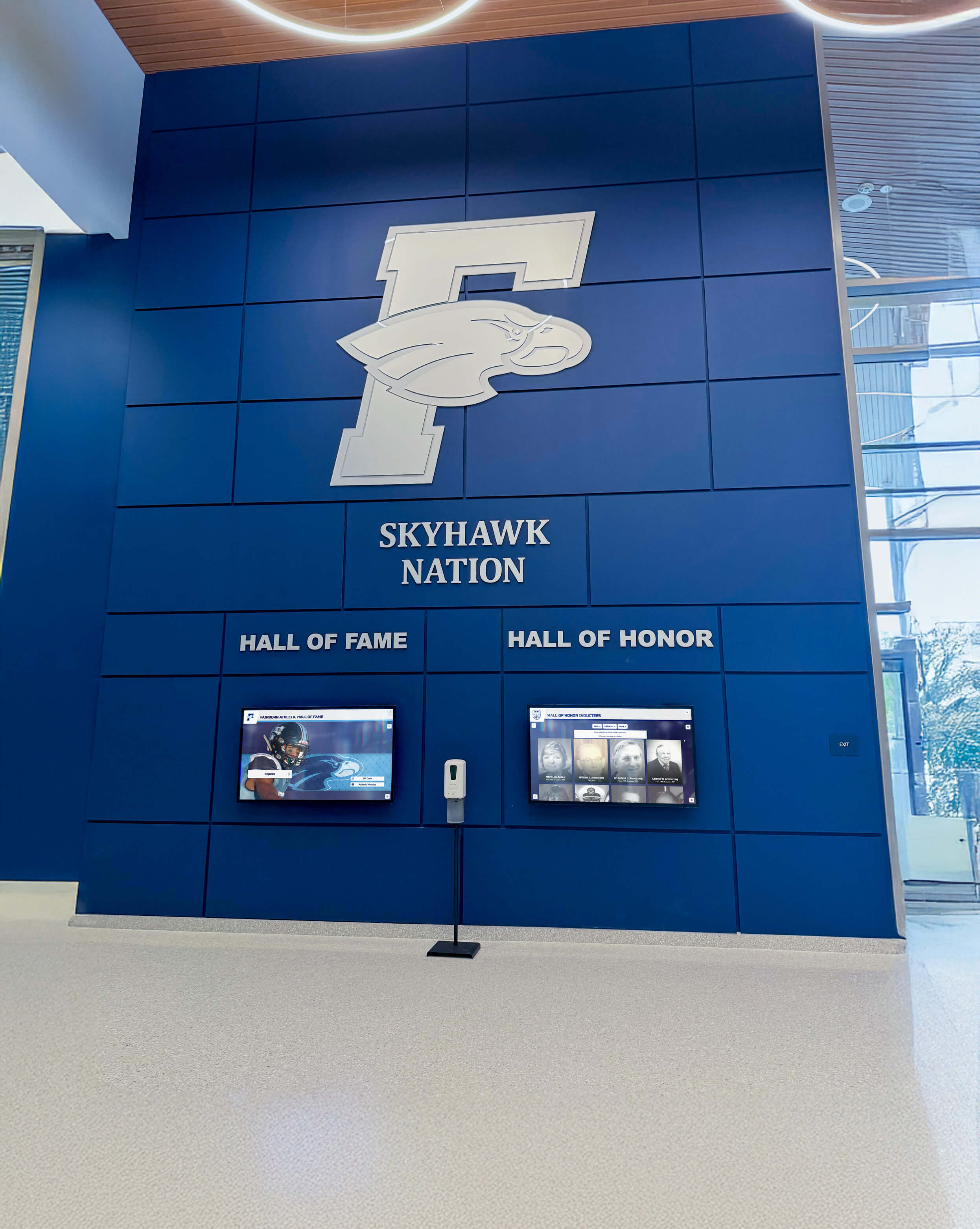 School lobby featuring wall of fame and honor recognition displays Skyhawk Nation lobby with blue wall of fame and honor displays