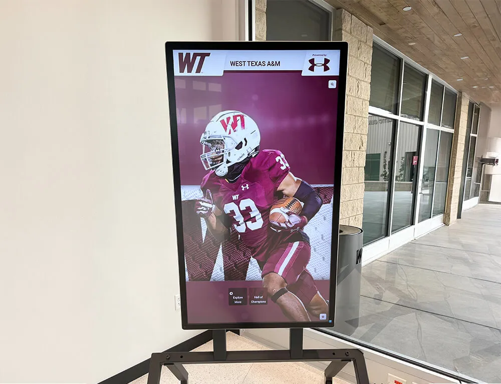 Number 33 football player on a digital lobby display at West Texas A&M — a high-production recognition format that extends football senior banner identity into a permanent digital environment West Texas A&M number 33 football player digital display in arena lobby